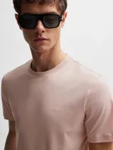Remera de algodón de corte regular, color gris oscuro, con cuello redondo y logo de la marca bordado discretamente en el pecho.