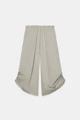 Pantalón culotte de tiro medio con cintura elástica, bolsillos laterales ocultos y bajo con abertura ajustable mediante cordones laterales.