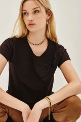 Remera de algodón color marrón oscuro con escote en V y dos apliques bordados en forma de corazón en el frente.