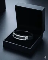 Pulsera de diseño moderno con estructura central de acero inoxidable y laterales de goma negra. Presenta un detalle central con el patrón de guarda griega grabado sobre fondo negro.
