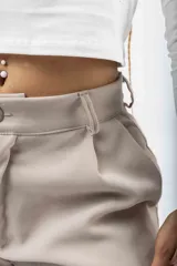 Pantalón de corte sastrero y tiro bajo, con diseño de pierna ancha y holgada. Presenta cierre frontal con botón y bolsillos laterales.