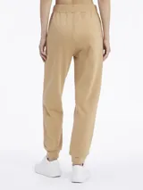 Pantalón de jogging color beige, de corte relajado y tiro medio, con puños ajustados en los tobillos.