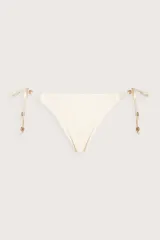 Calzón de bikini color crema con tiras laterales ajustables y detalles de cuentas metálicas doradas en los extremos.