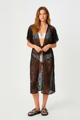 Kimono largo de encaje color negro, con diseño calado, mangas cortas amplias y cierre frontal mediante lazo ajustable en la cintura.