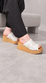 Zuecos Dakota de cuero marfil con textura croco, con plataforma corrida y suela de goma marrón.