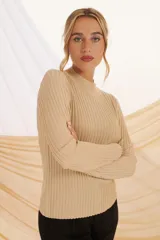 Buzo de tejido de punto color beige con lurex plateado, de cuello alto y mangas largas.