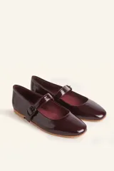 Zapatos tipo Mary Jane con estampado de piel de serpiente, capellada de cuero vacuno, forro y plantilla de cuero vacuno, y suela de cuero. Tienen un taco bajo de 1 cm y una correa con hebilla negra sobre el empeine.