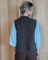 Chaleco tejido en lana 100% lambswool, con diseño de trenzas, cuello redondo y cierre frontal con botones tipo carey. Presenta bolsillos frontales integrados.