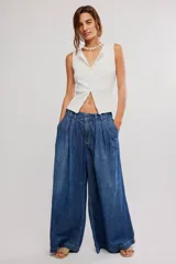Pantalón de denim celeste de tiro bajo, pierna muy ancha y diseño sastrero con tablas al frente. Cuenta con cintura fruncida en la espalda, bolsillos y cierre frontal con cremallera y gancho.