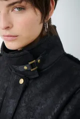 Chaquetón de efecto cuero en color marrón, con interior y detalles en corderito color bordó. Presenta cierre frontal con cremallera y botones a presión, cuello solapa y mangas largas con puños de corderito.