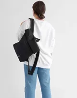 Mochila acolchada color beige con cierre superior enrollable y hebilla.