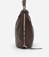 Bolso hobo grande de poliuretano color bordó, de diseño desestructurado con asas dobles y cierres laterales ajustables con tiradores. Cuenta con cierre superior y herrajes metálicos plateados.