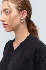 Sweater de tejido de punto color beige, con escote en V y calce holgado.