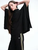 Poncho amplio de cuello alto, confeccionado en hilado con lana y cashmere, con diseño de caída recta y botones laterales.