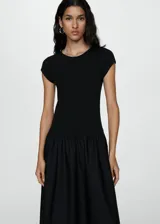 Vestido midi de color negro con diseño combinado. Presenta un cuerpo superior ajustado de tejido de punto con cuello redondo y mangas cortas, y una falda inferior amplia con vuelo confeccionada en algodón.