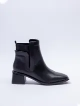 Bota de cuero negra, de caña media, punta cuadrada y pieza elastizada en los laterales.