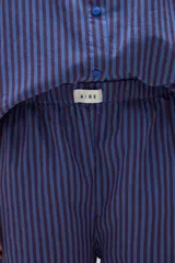 Pantalón de pijama de algodón con diseño de rayas verticales en tonos azul y bordó, corte holgado, cintura elástica y botamangas con vuelta.