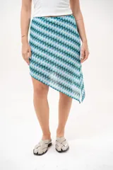 Falda asimétrica de crochet con diseño de ondas en tonos azules, celestes y blancos.