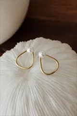 Aros colgantes de bronce dorado con perlas blancas.
