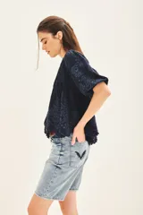 Camisa de manga corta color azul oscuro con efecto denim, cuello redondo con abertura en V y bordado floral en hilo a tono.