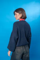 Sweater color beige de lana mohair y acrílico, con cuello redondo y mangas largas.