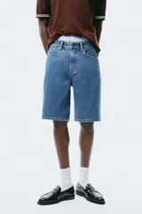 Bermuda de cinco bolsillos en denim de algodón grueso. Modelo de cintura estándar con cierre y botón, y piernas de corte relajado.