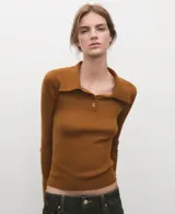 Jersey de punto color mostaza, con cuello polo y cierre frontal parcial de botones, de manga larga y diseño ajustado.