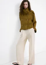 Pantalón largo de tiro medio, color beige, con diseño recto, trabillas para cinto y bolsillos laterales.