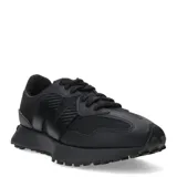 Championes urbanos New Balance modelo 327, color negro, confeccionados en una combinación de malla y material sintético. Presentan el logo 'N' característico en el lateral y una suela dentada que se extiende hacia el talón.
