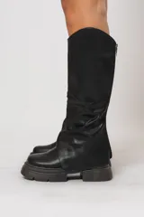 Bota bucanera negra de cuero sintético con caña alta y suela track.