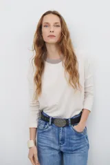 Remera de manga larga color bordó con cuello redondo en contraste color crema y costuras decorativas visibles en el ruedo y puños.