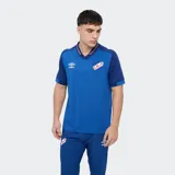 Remera polo de fútbol Umbro del Club Nacional de Football, color azul con cuello en V y detalles en rojo y blanco.