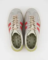 Championes Coolway modelo Kizuna de corte clásico, color gris claro con detalles en rojo y amarillo. Fabricados en ante y nylon, con suela color miel.