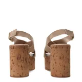 Sandalias de plataforma alta estilo cuña fabricadas en corcho. Presentan tiras cruzadas en el empeine de gamuza color marrón oscuro y cierre mediante pulsera con hebilla metálica al tobillo.