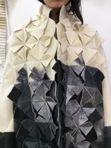 Tapado largo de lana merino afieltrada, color natural combinado con gris, con textura "cubo" en el frente.