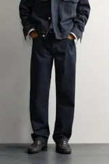 Pantalón jeans straight fit de tiro bajo, confeccionado en denim de algodón oscuro sin lavados, con diseño de pierna recta, cinco bolsillos y cierre frontal de botonadura.
