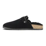 Zueco casual de mujer color negro, confeccionado en material tipo gamuza con interior forrado en corderito sintético. Presenta una hebilla metálica ajustable en el empeine y una suela con detalle de corcho y base antideslizante.