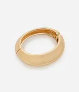 Pulsera rígida dorada con resorte, confeccionada en metal reciclado.