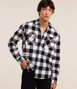 Camisa de franela de algodón con estampado de cuadros blancos y negros, corte regular, cuello inglés, manga larga y abotonado frontal.
