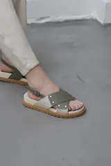 Sandalias bajas color verde oliva, con dos tiras anchas cruzadas sobre el empeine y tira trasera con hebilla.