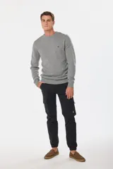 Pantalón cargo azul marino con bolsillos laterales con solapa y cinturón de cuero marrón.