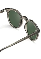 Lentes de sol redondos con montura gris translúcido y lentes verdes. Fabricados con acetato biodegradable y lentes de PMMA reciclado.