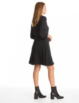 Vestido de crepe color marrón, con cuello solapa, escote en V y cintura elastizada. Presenta bolsillos simulados con cierres metálicos en el frente y mangas largas regulables con presilla y botón.