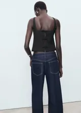 Top negro sin mangas de cuello cuadrado y tirantes anchos, con diseño recto y cierre de cremallera lateral.
