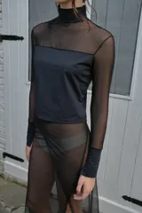 Polera negra de microtul y lycra compression, con cuello alto, mangas largas y puños de lycra. Presenta una abertura sutil en los puños.