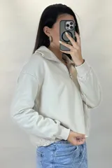 Buzo deportivo color blanco con cuello polo y cierre frontal parcial. Presenta mangas largas con puños elásticos y ruedo ajustable con cordón elástico.