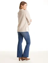 Buzo de tejido soft mohair con estampado zigzag en tonos beige y blanco. Presenta cuello polo, escote en V con botones a presión y manga larga amplia. El bajo tiene tajos laterales y apliques metálicos.