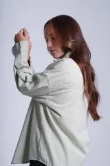 Sobrecamisa color beige de gabardina con cuello camisero, cierre frontal con botones a presión, dos bolsillos de parche en el pecho y corte holgado.