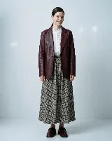 Blazer de cuero bovino color bordó, con silueta entallada, solapas clásicas y cierre frontal con un botón. Presenta mangas largas con detalles fruncidos que aportan textura.