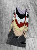 Top corto negro brillante con breteles finos y escote en V.